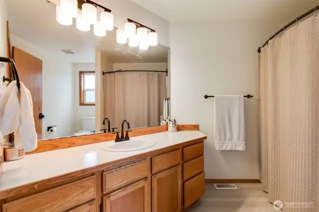 Guest bathroom features an oversized vanity w/tons of storage, new lighting & new flooring!