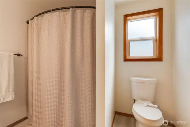 Guest bathroom boasts NEW luxury vinyl plank flooring, a shower/tub combo and dual flush toilet.