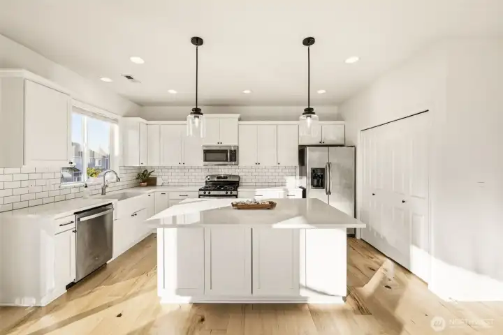 White quartz counters and stainless steel appliances.