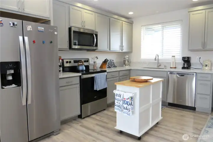 The chef will enjoy the stylish cabinetry, stainless steel appliances, exquisite quartz counters and island prep area.