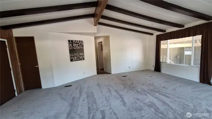 NEED SPACE FOR THE LARGE ENTERTAINMENT CENTER? TAKE A LOOK AT THIS HUGE LIV. ROOM WITH VAULTED BEAM CEILING AND NEW CARPET LAST WEEK. OFFERS ANBUNDACE  OF DAYLIGHT WITH THE HUGE WINDOWS. [[SAVINGS ON THE ELECTRIC BILL]]