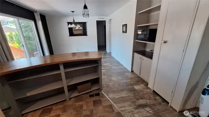 MORE COUNTERTOP AND STORAGE. LARGE PANTRY ON  RIGHT. MORE STORAGE AND SHEVES MICROWAVE FITS PERECTLY HERE. BEYOND THE KITCHEN YOU SEE A GOOD SIZE ROOM. CAN BE  A FAMILY ROOM OR DINNING RM.