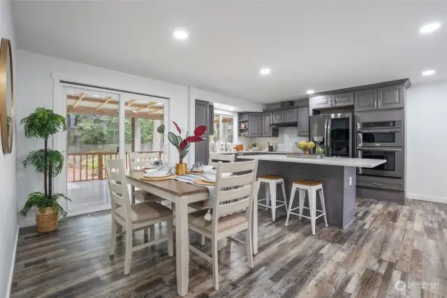 The dining room enjoys a large sliding glass door with easy access to a covered deck, perfect for enjoying year-round and for staying dry while barbecuing.