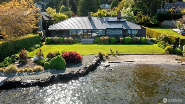 An exceptional property—this single-level home situated on a sunny, flat 18,948 square foot lot, features 88' feet of pristine low-bank waterfront with sandy beach. Gorgeous gardens are all irrigated with nutrient rich lake water.