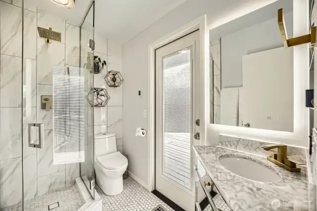 Primary ensuite bath with door to deck and hot-tub just outside