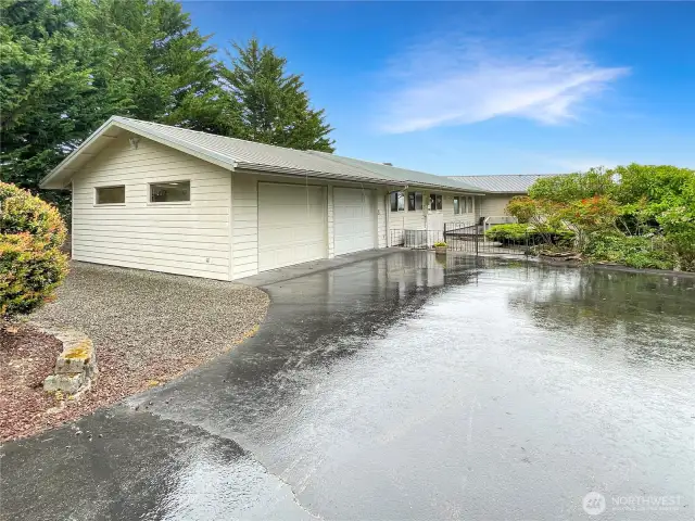 Black topped circle Driveway with two rodiron gates.