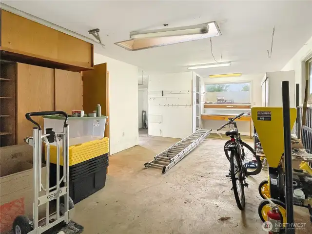 detached garage with cupboard, shelving and work benches.