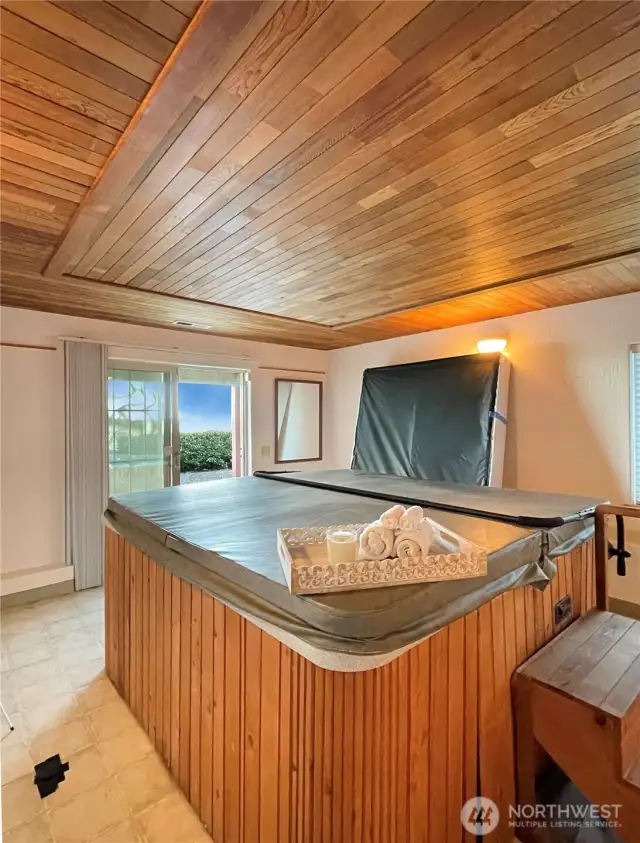 Hot tub in daylight basement. Slider out to small patio.