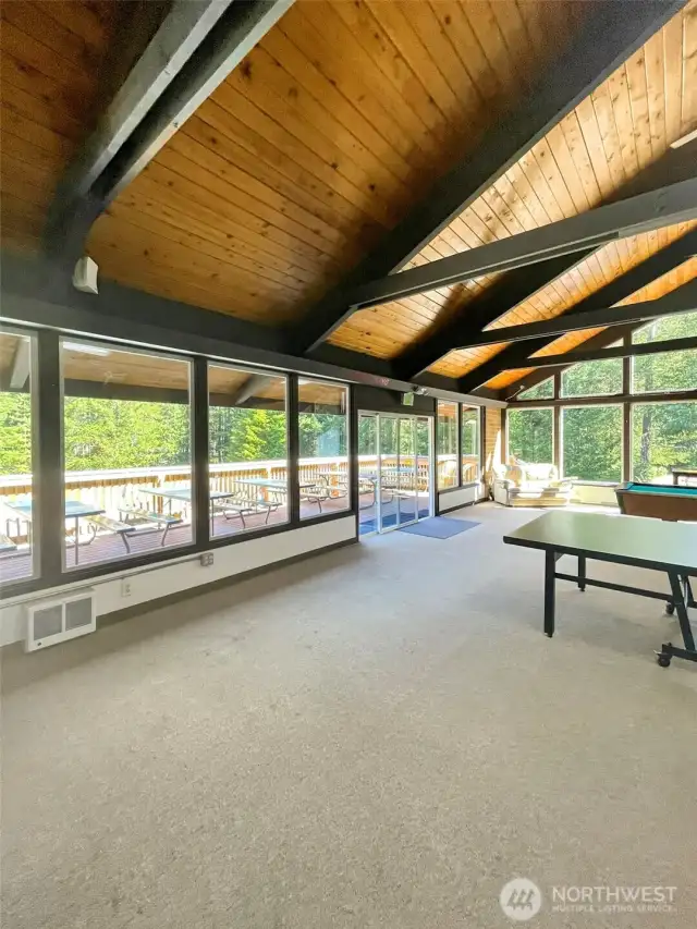 Large inside club house with fire place and table and chairs