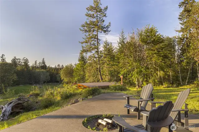 Peaceful outdoor patio with firepit and seating, surrounded by natural beauty and serene forest views.