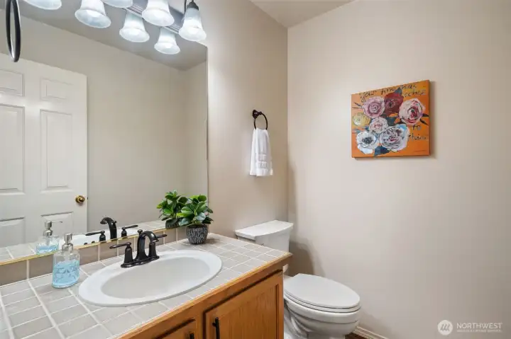 Powder room on main floor. Ceramic tiled vanity.