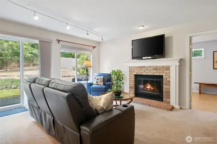Spacious family room with cozy fireplace opens to the backyard.