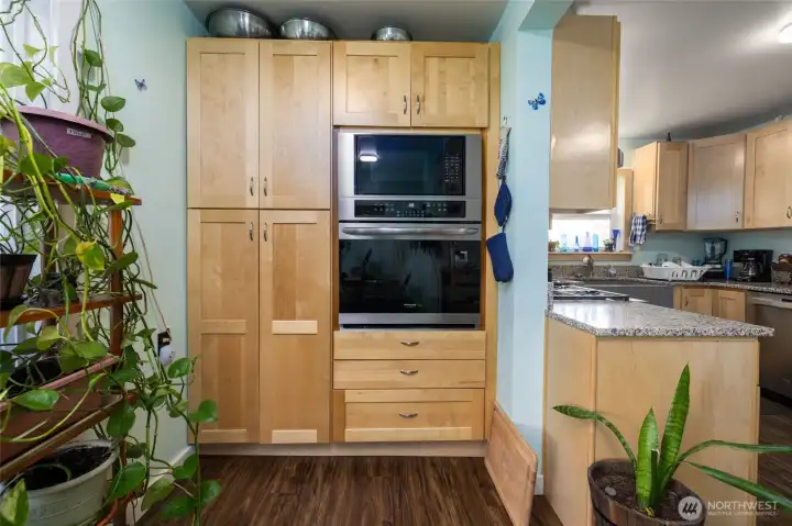 Wall oven was placed to allow easy transfer of hot foods from oven to countertop on the right. The deep pantry on the left offers plenty of additional storage.