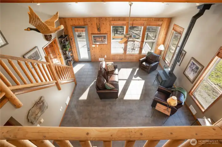 A fun view from the loft looking to the living room, staircase & the cozy wood burning stove!