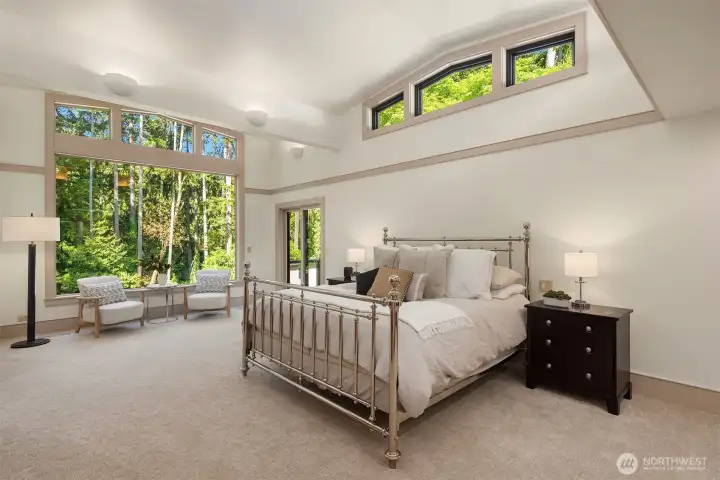 The main-floor primary suite is a true sanctuary, featuring dramatic clerestory windows that frame stunning backyard and park views.