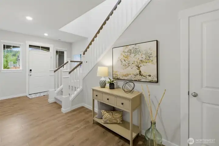 The entry is large and open with light streaming in from the upstairs windows.