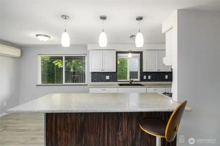 Well appointed kitchen with granite sink and eating bar.