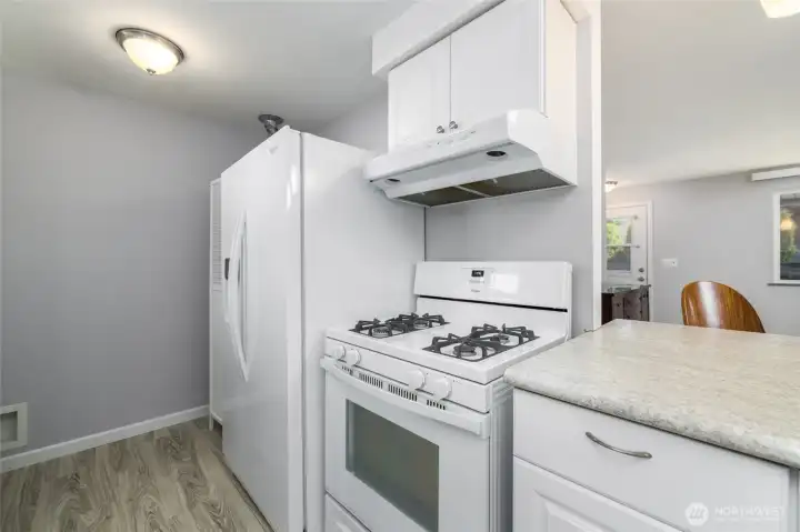 Side by side fridge and gas stove compliment the kitchen.