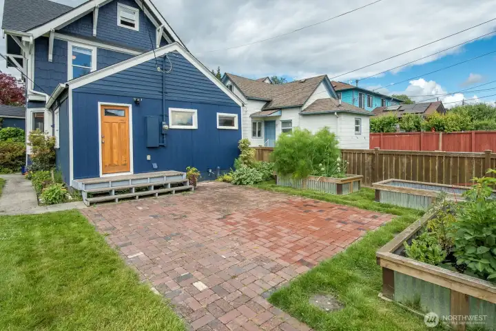 Step outside to a large patio with multiple raised vegetable garden beds! Step outside to a large patio with multiple raised vegetable garden beds!