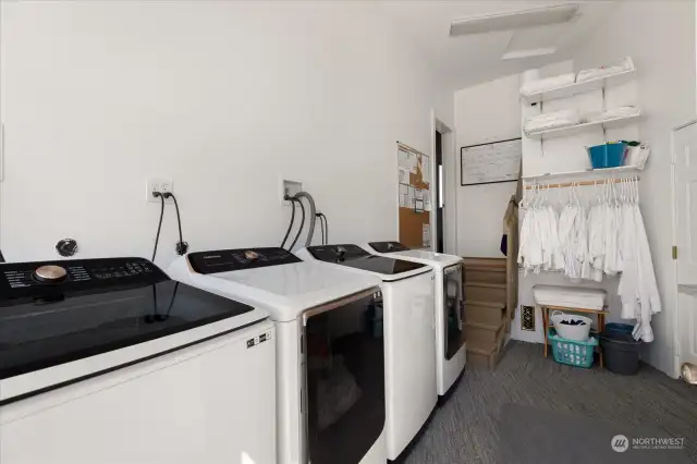 Laundry room with 2 sets of oversize washer/dryers.