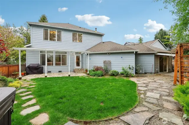Maintained backyard with patio, hot tub, and swing seating