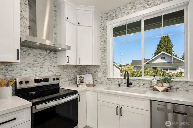 Kitchen sink framed by large window allowing natural light in.