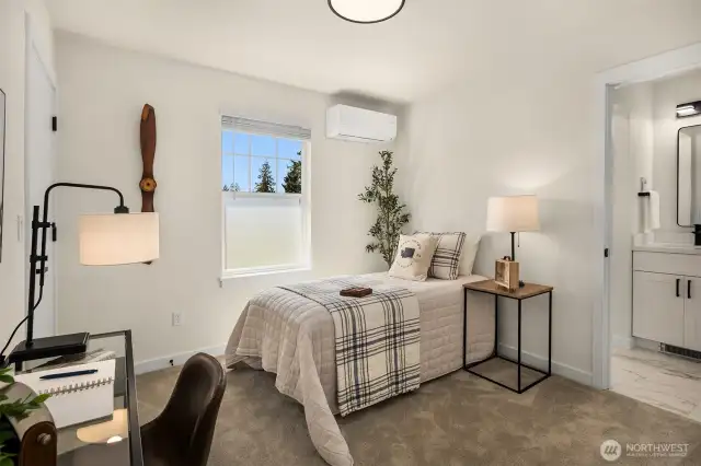 Spacious bedroom with access to bathroom and large window providing natural light.