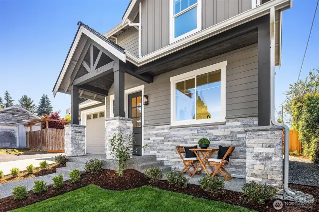 Front of home featuring covered seating area.