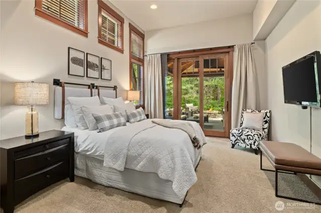 The main floor primary suite with high ceilings and private patio access.