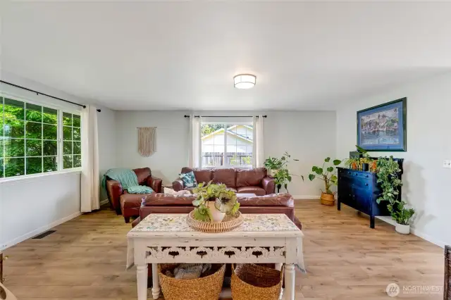 From the entry way, this roomy light-filled living room awaits.