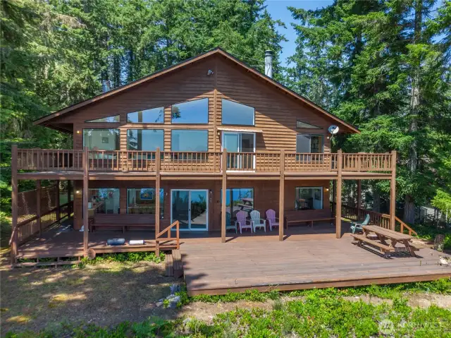 Expansive deck perched above high-bank waterfront offers panoramic views — with stairs leading down to your own secluded beach retreat.