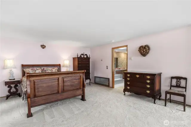 Very large primary bedroom features French doors opening to the wrap-around deck and includes a private en-suite bathroom for added comfort and privacy.