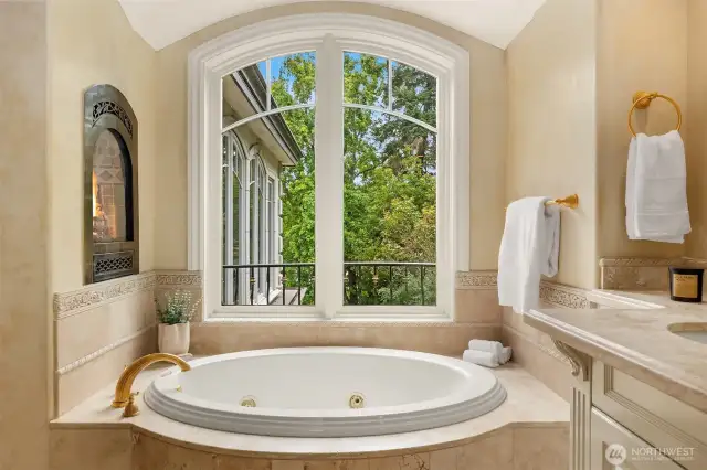Jetted tub in master bathroom with built-in fireplace