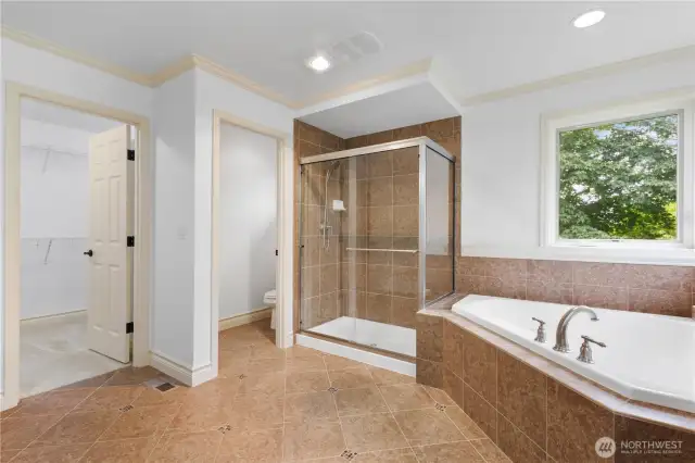 Spa-like ensuite bath with soaking tub, walk-in shower, and dual vanities.