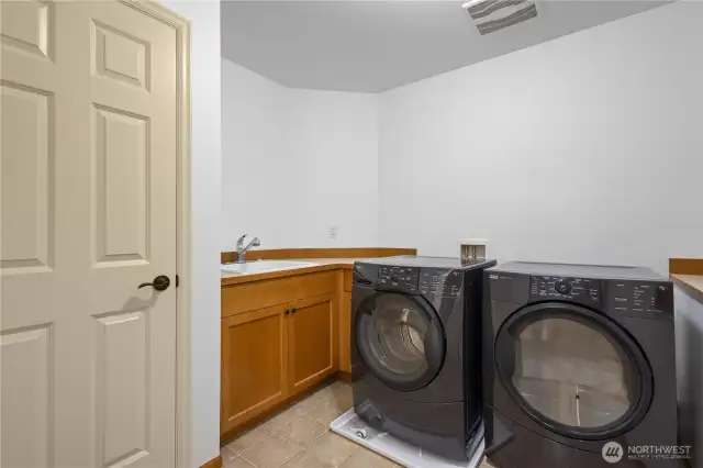 Spacious laundry room with utility sink and built-in storage.