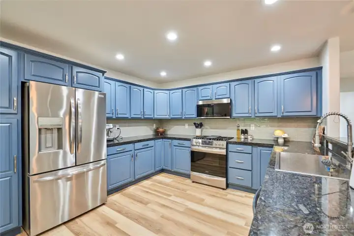 The kitchen opens to the informal dining area and the living room. It's been remodeled with new backsplash, new appliances, new sink & faucet, new hardware and painted cabinets.