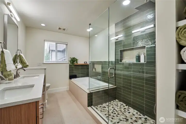 The spa inspired primary bathroom has been recently remodeled and offers dual vanities, a soaking tub, large shower enclosure with custom tilework and plenty of storage.