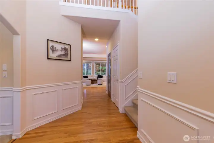 An elegant entry with detailed millwork, wainscoting, and hardwood floors leading into light-filled living spaces. The open sightline highlights the home’s generous scale and refined architectural details.