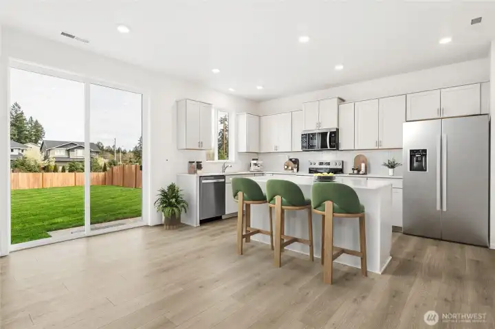 Kitchen features island for additional seating and tons of cabinet space. Virtual Staged.