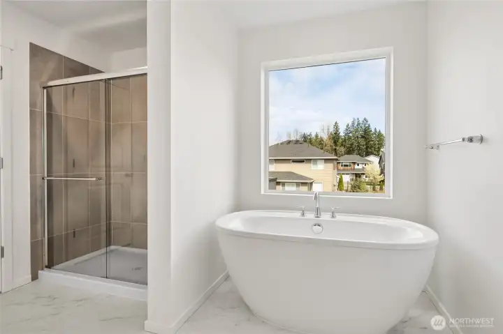 Spa like primary bathroom with freestanding tub & tiled shower.
