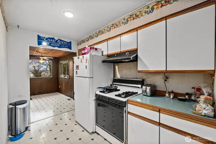 Looking back toward the front door (right side, beyond the fridge) and into the dining room.
