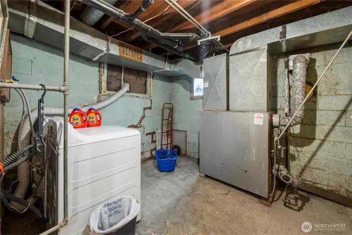 The utility room is located at the end of the hallway and just around the corner from the lower level door to the backyard. This would make a great mudroom.