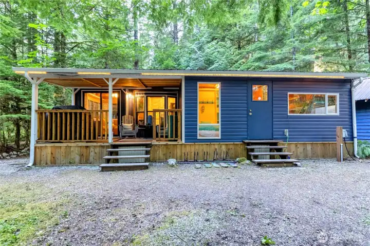 Full exterior view of park model with covered porch and addition