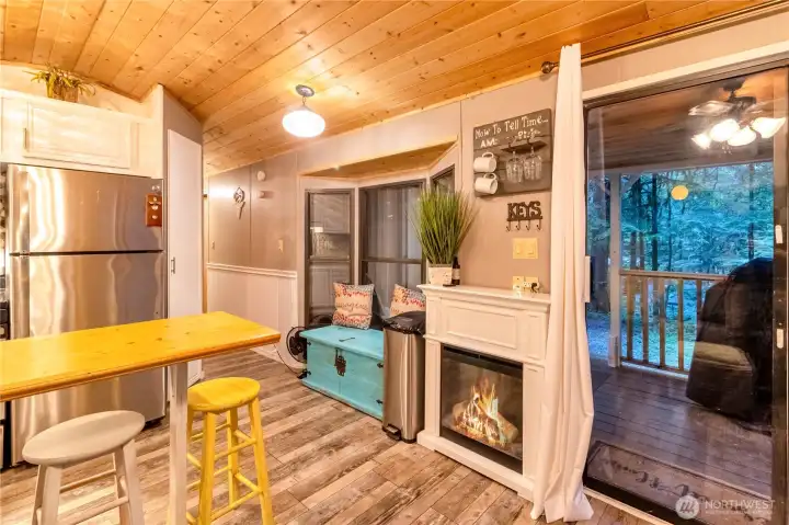 Kitchen and dining area with bar-height seating and fireplace feature