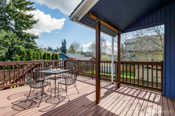 Deck off kitchen overlooks spacious back yard.