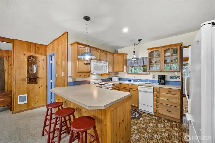 Functional kitchen with peninsula seating, ample cabinetry, and open sightlines to the living room.