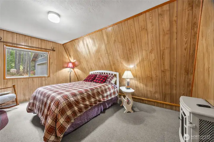 Cozy main-level bedroom with rustic wood finishes, perfect for relaxing after exploring Packwood and White Pass.