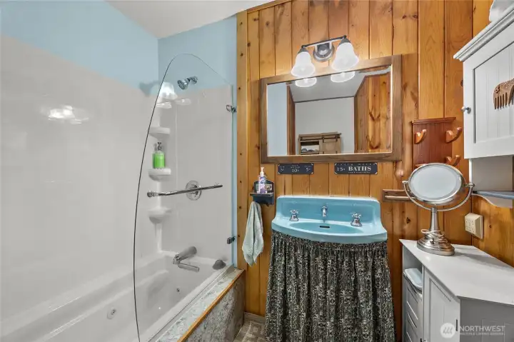 Full bathroom with tub/shower combo serving this cozy Packwood cabin near outdoor recreation and trails.