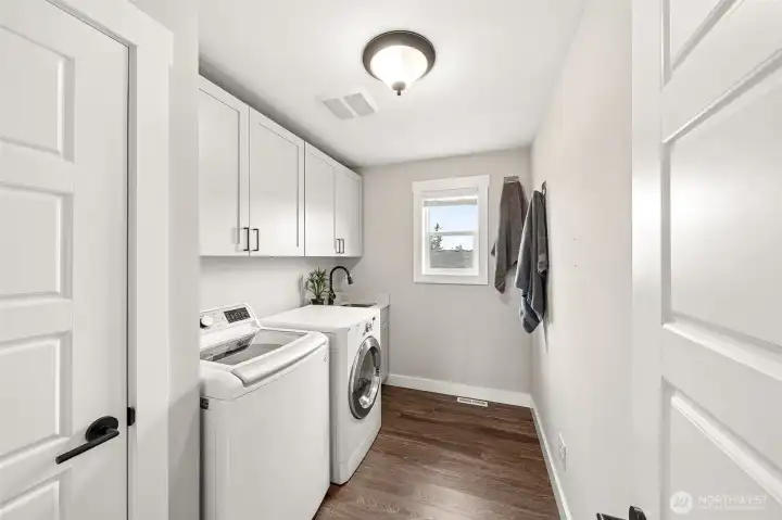 Upstairs utility/laundry room with sink and linen closet