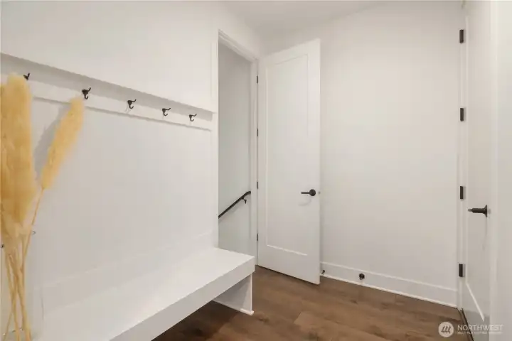 Main floor mudroom from garage entrance to the right. Stairway to lower level to the left